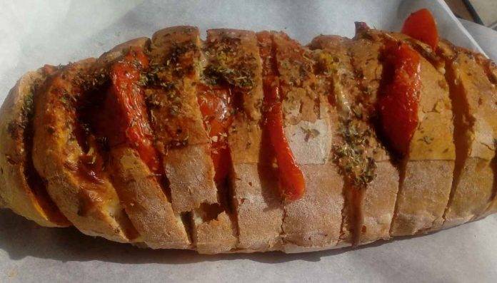 Pane condito al forno | Ricetta saporita e veloce di bell’effetto
